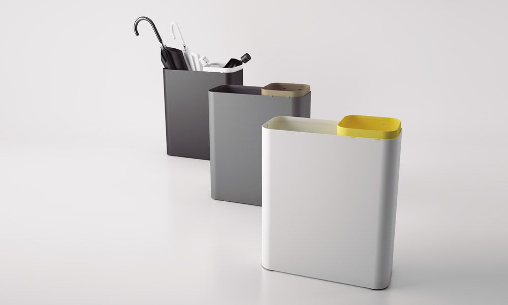 Tres paragüeros están alineados uno al lado del otro sobre una superficie blanca.