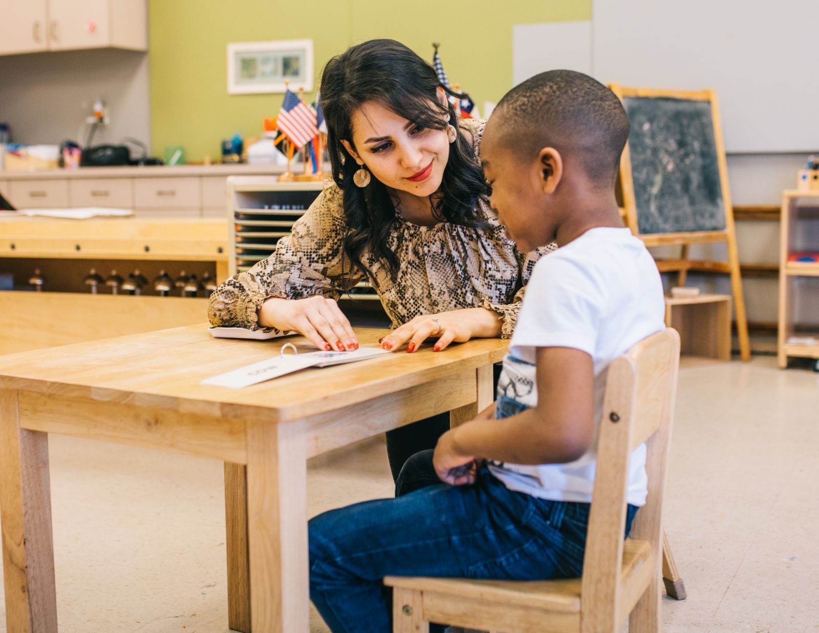 A woman is sitting at a table with a child.