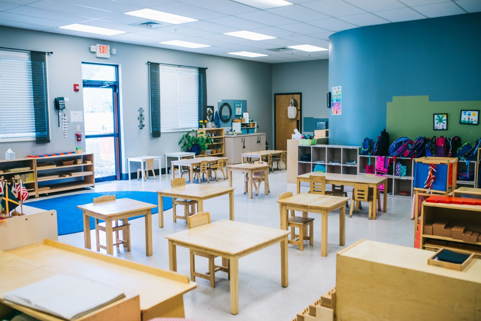 A classroom with lots of tables and chairs in it.