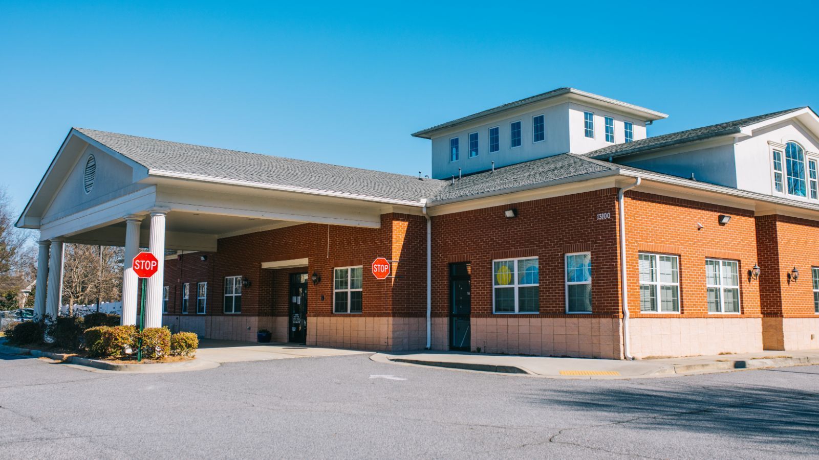 A large brick building with a stop sign in front of it.