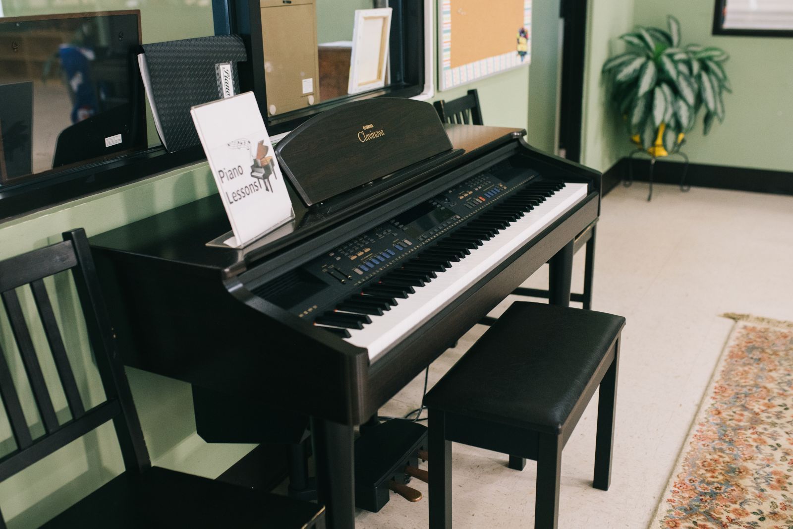 A piano is sitting in a room next to a bench.