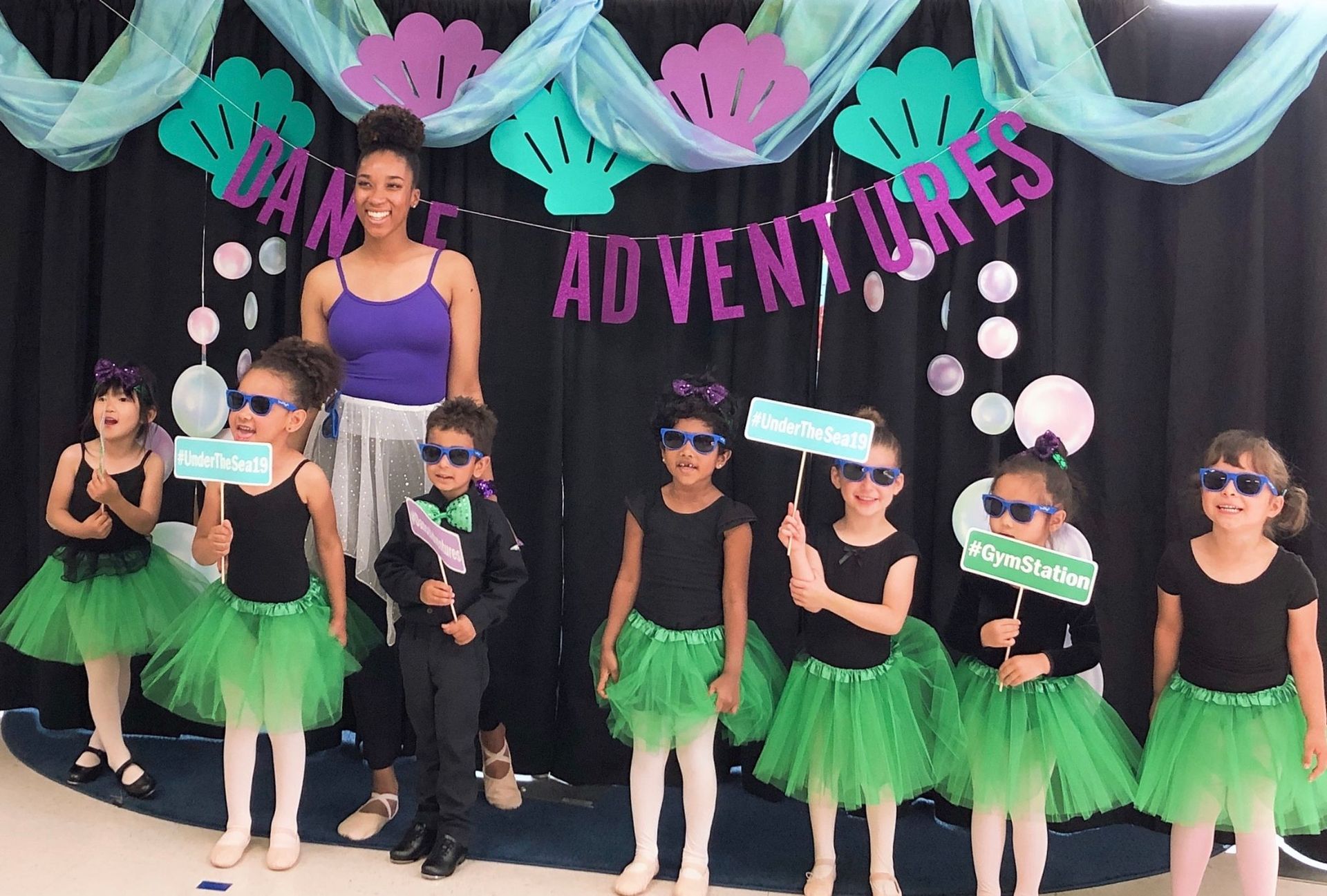 A group of children are standing in front of a sign that says adventures