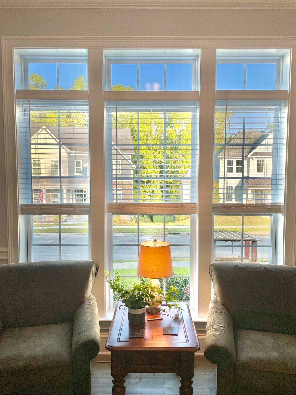 A living room with two chairs a table and a lamp