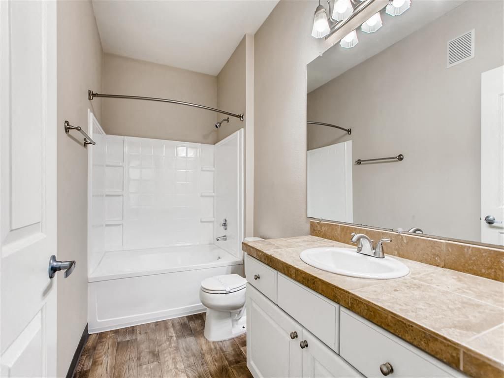 Bathroom in an apartment unit with a tub/shower combo, toilet, and vanity.