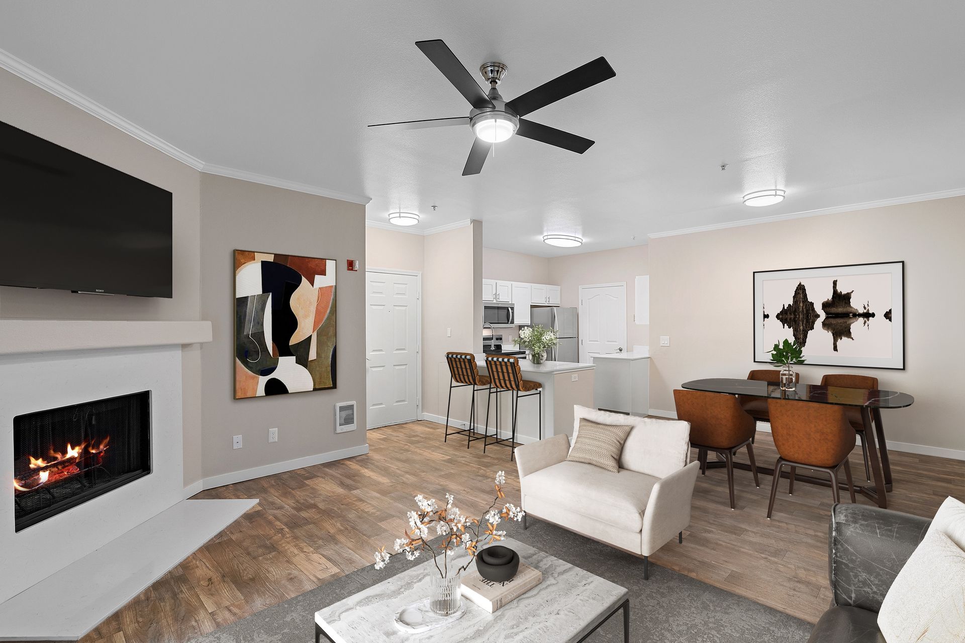 Open-concept living area with sofa, dining table, fireplace, and kitchen island.