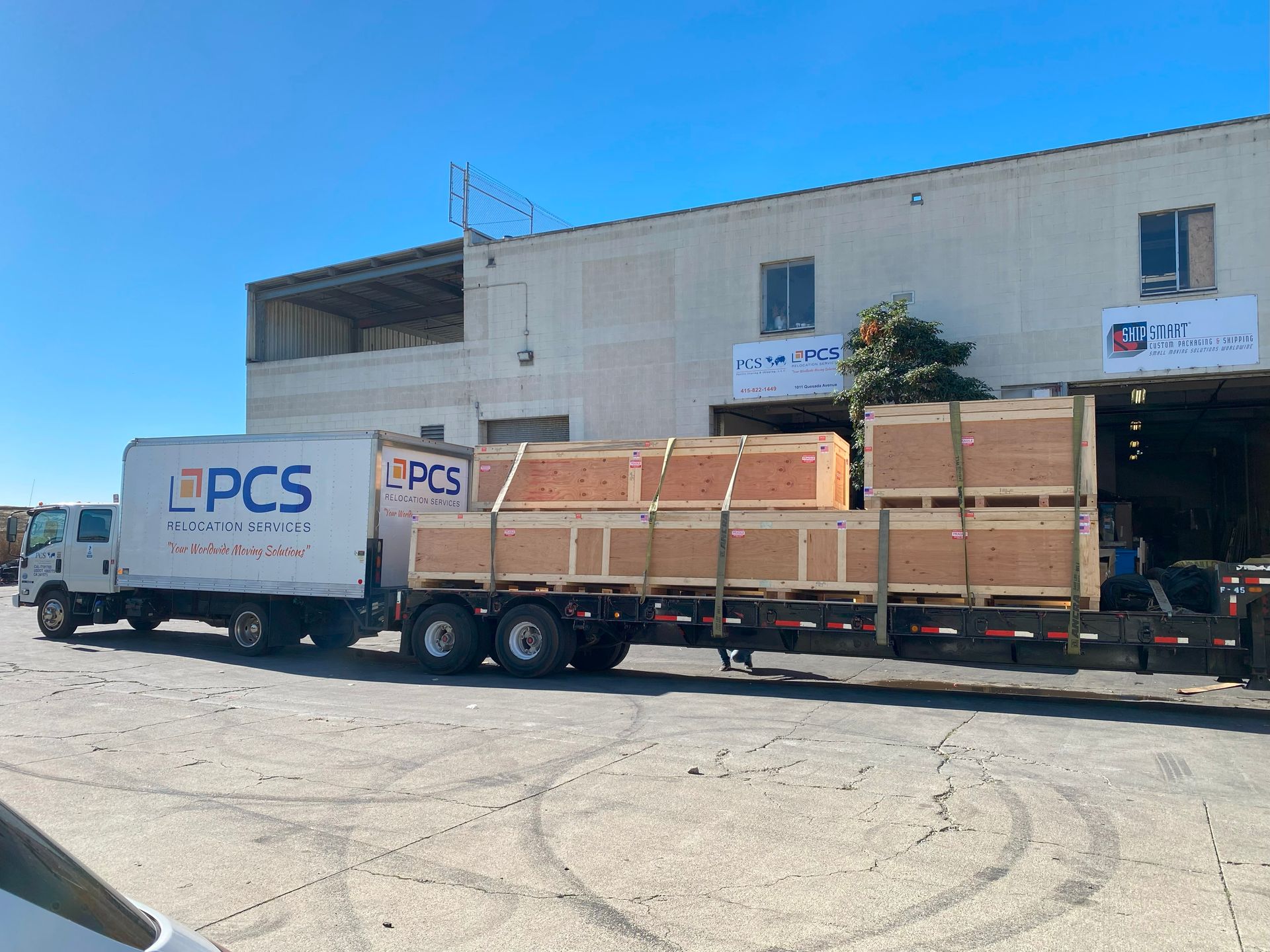 A white truck with the word pcs on it is parked in front of a building.