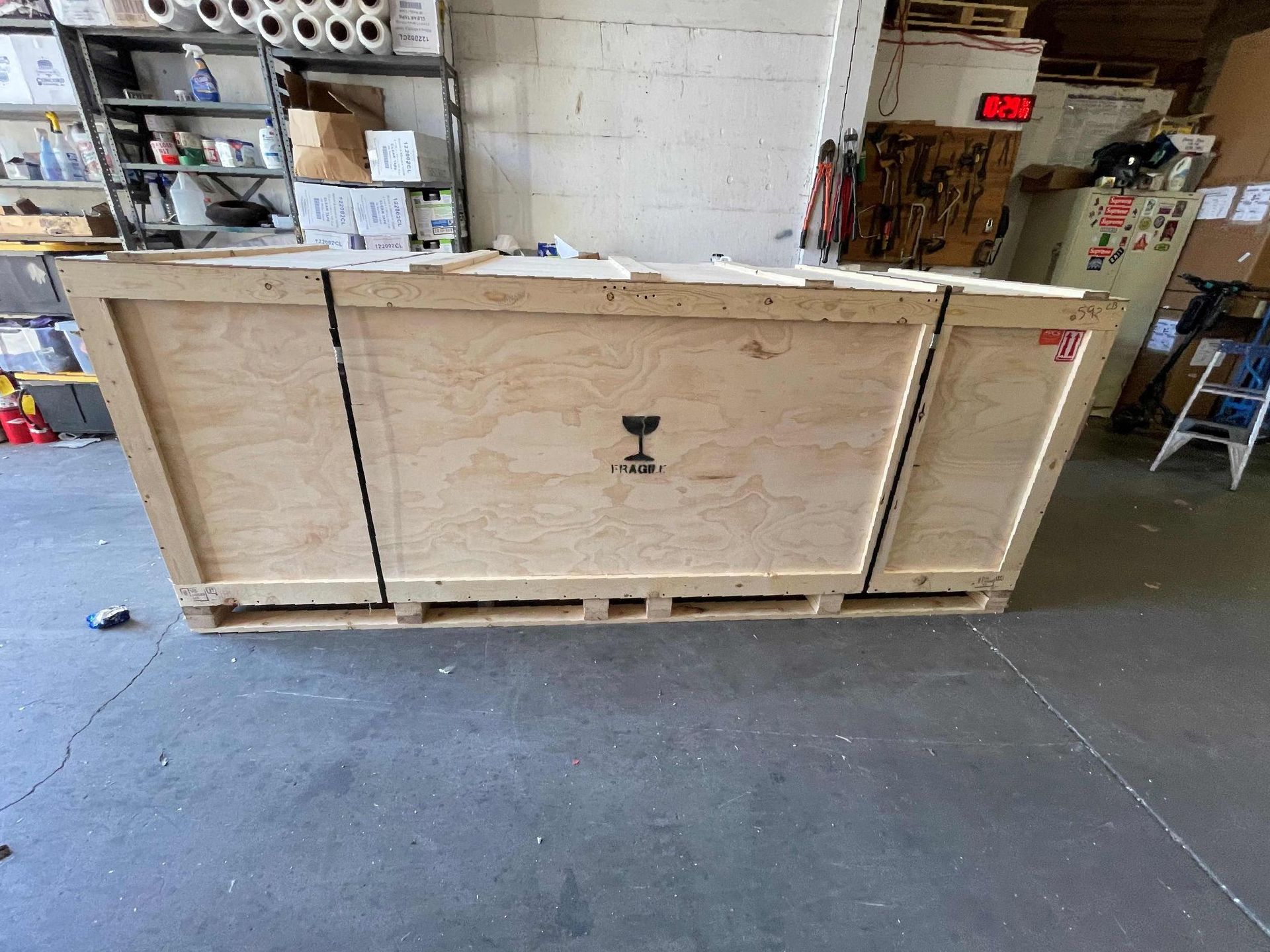 A large wooden crate is sitting on the floor in a room. Expert and customized crating and shipping service in California.