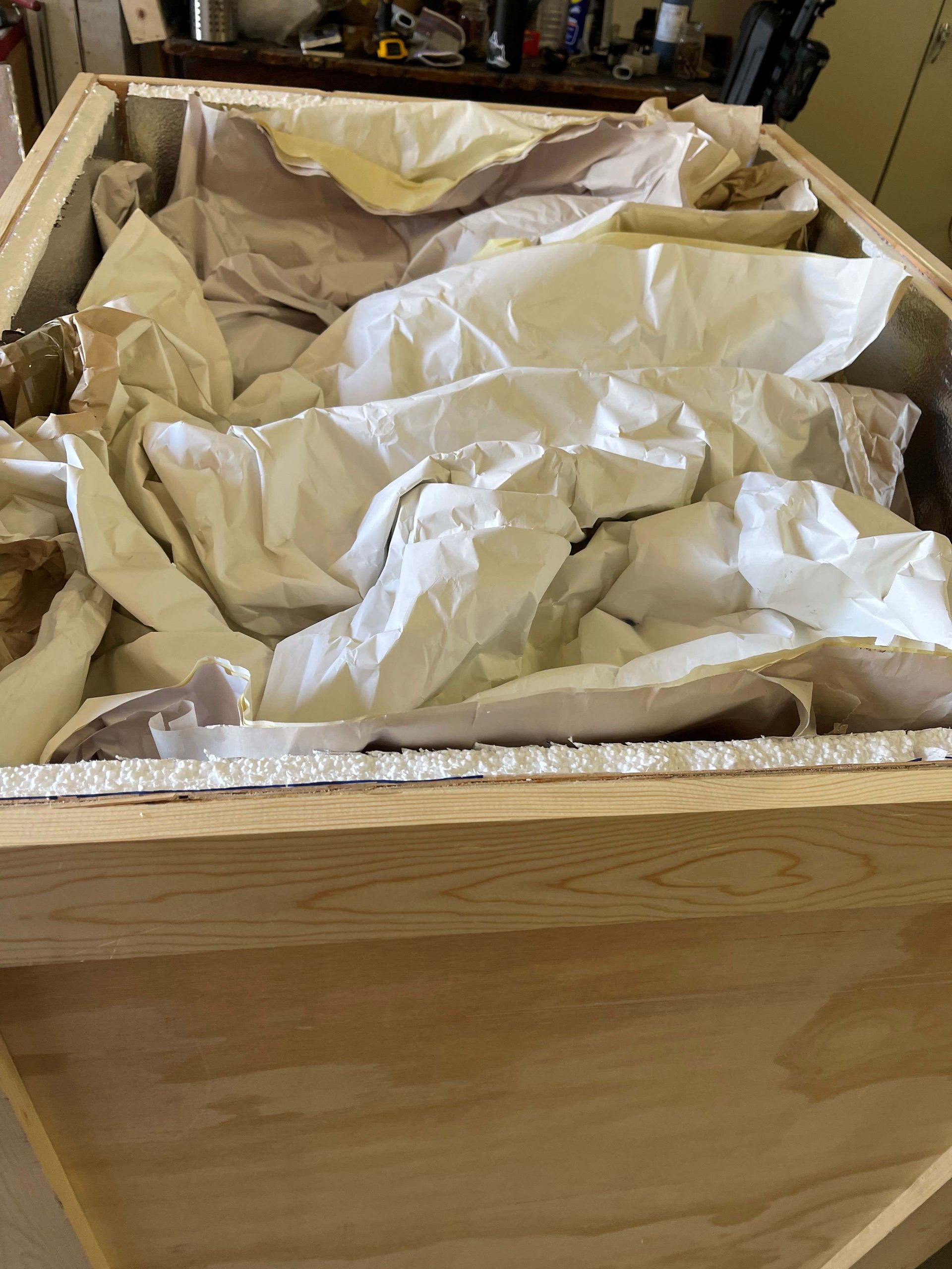 A wooden box filled with lots of white tissue paper.