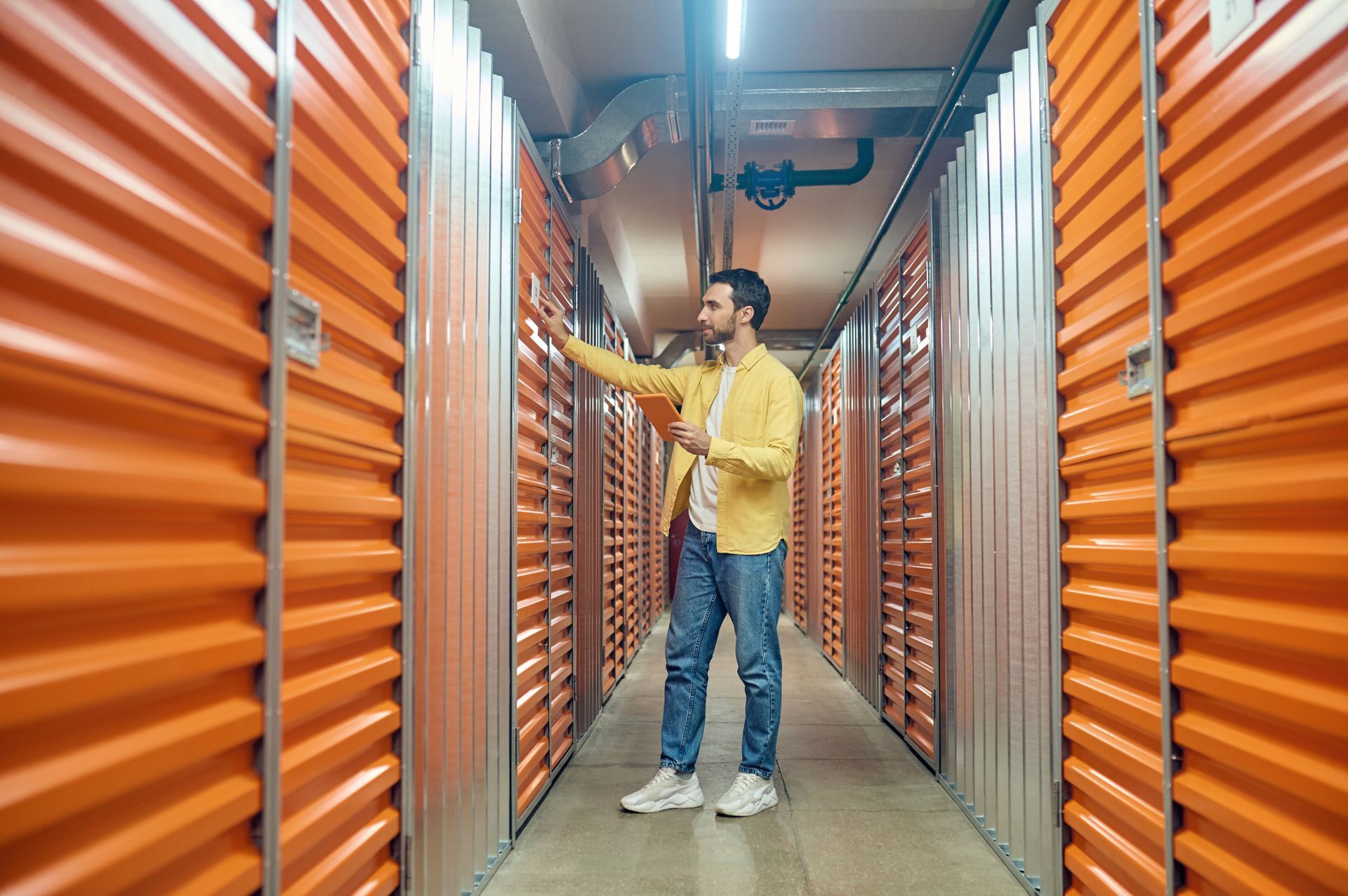 A man is standing in a hallway filled with orange walls.