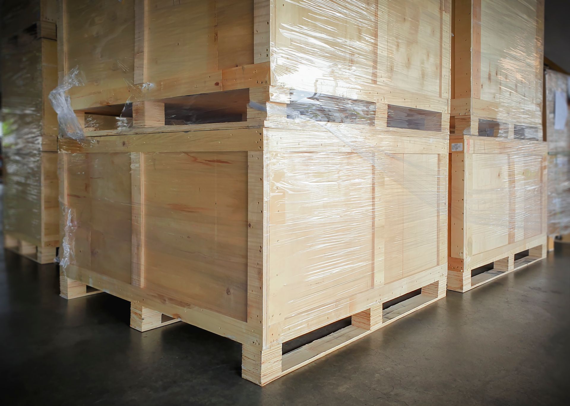 A row of wooden crates sitting on top of wooden pallets in a warehouse.