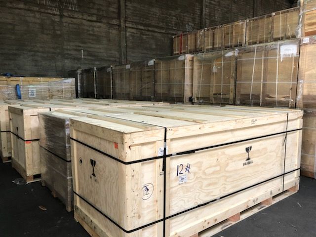 Wooden crates stacked in a warehouse, likely holding fragile items.