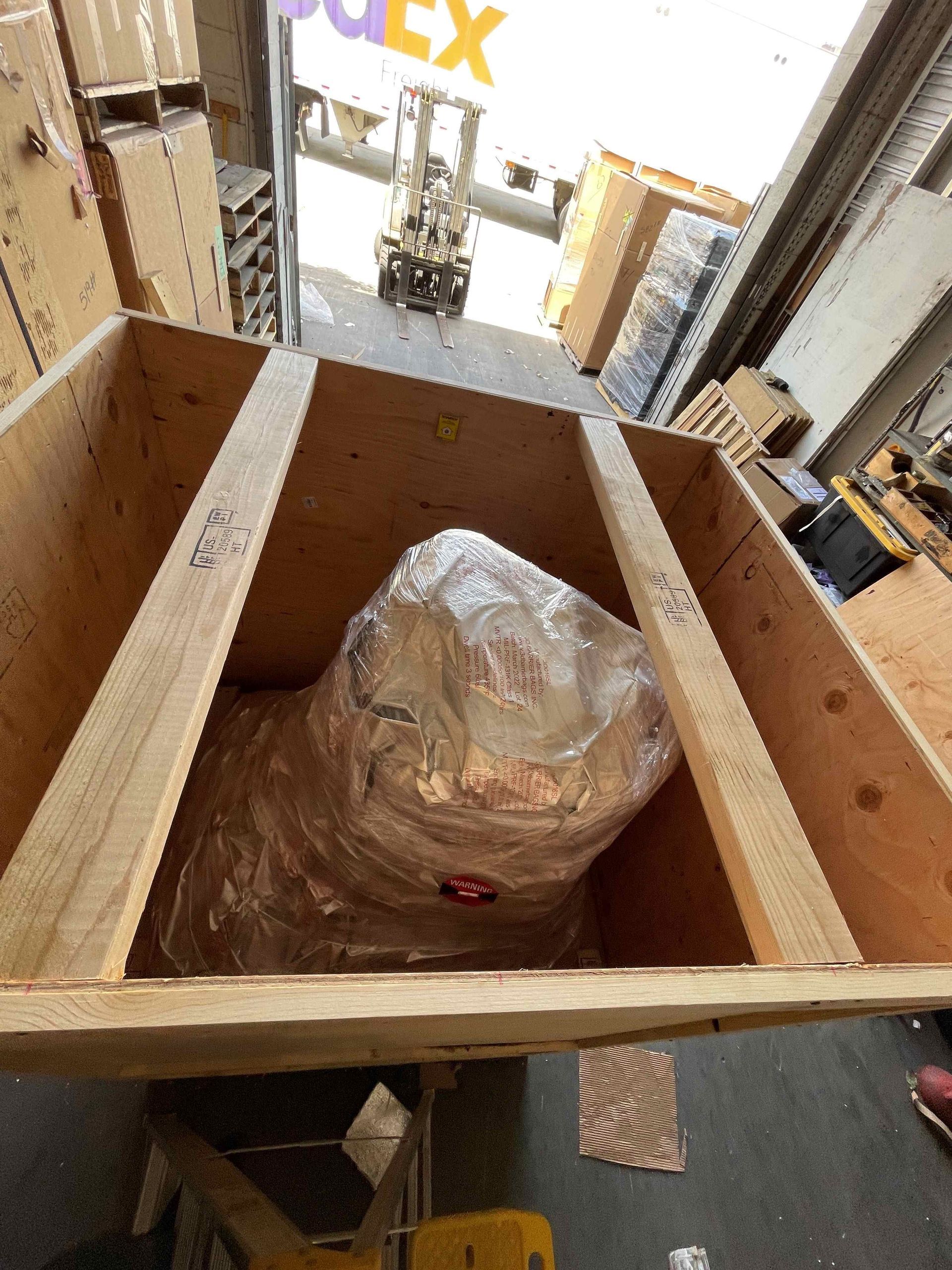 A large wooden box with a fedex sign in the background
