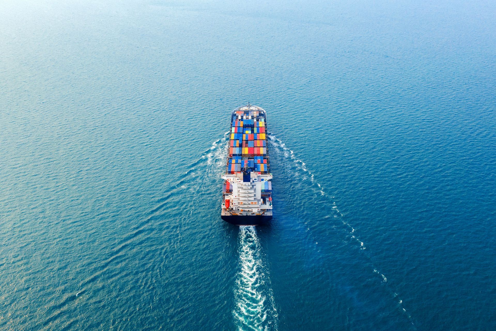 An aerial view of a large container ship floating on top of a large body of water.