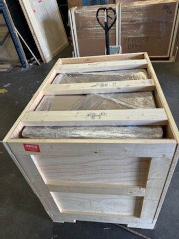 A wooden crate is sitting on the floor in a warehouse.