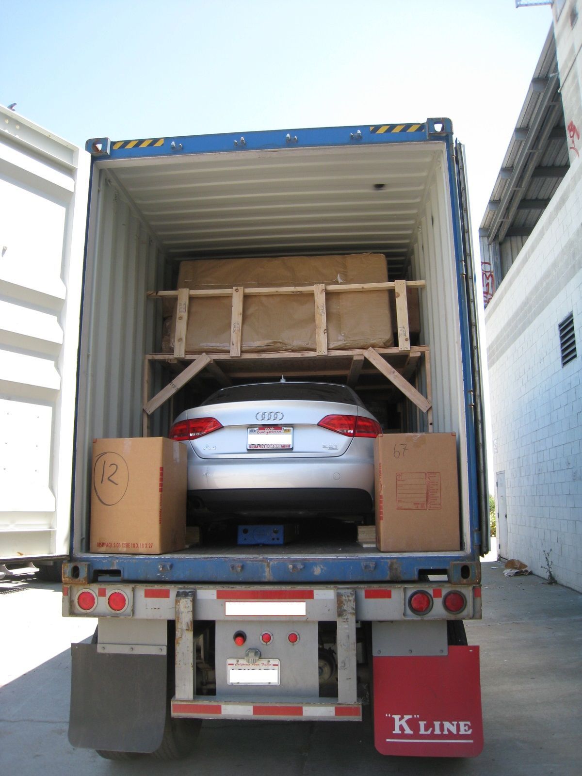 A kline truck is loaded with boxes and a car