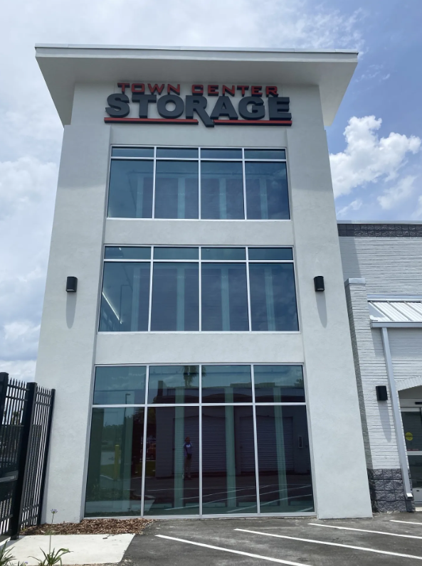 A large white building with a lot of windows and a sign that says town center storage.