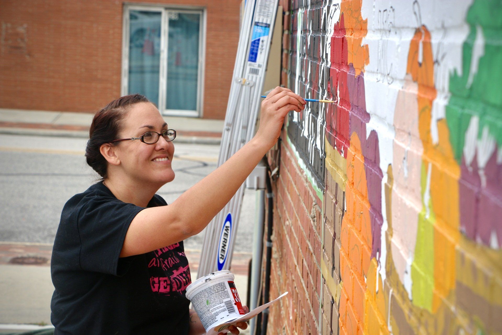 Picture of Elyse Johnson painting the Farmers Day mural in Coats, North Carolina