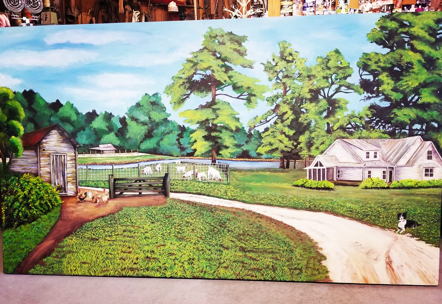 Photo of a mural of a farmhouse, a pond, and goats in a fence