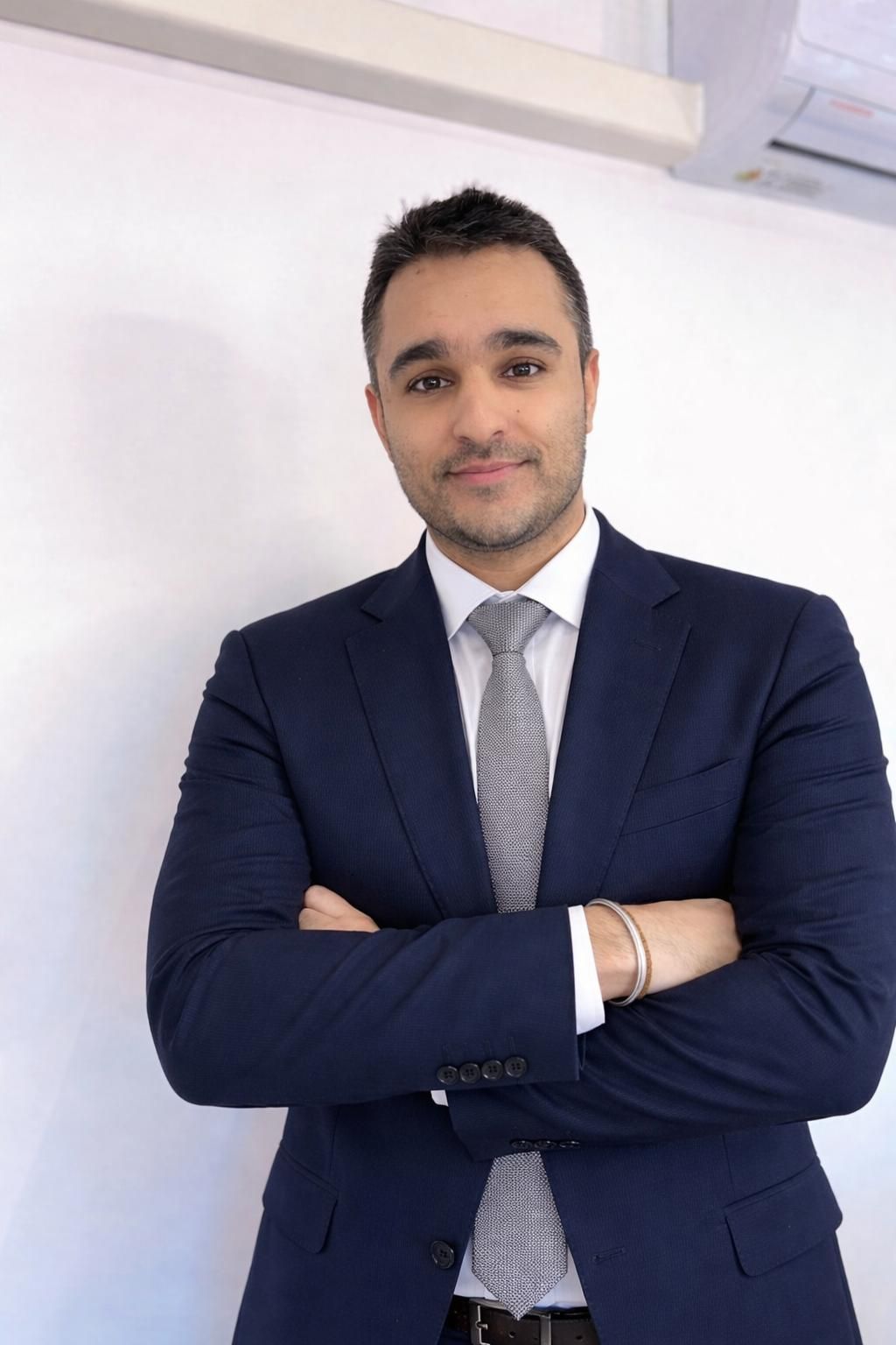 Un homme avec une barbe et une moustache sourit à la caméra.