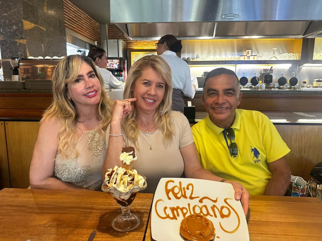 Dos personas sentadas en la mesa de un restaurante con un plato de postre y un plato que dice