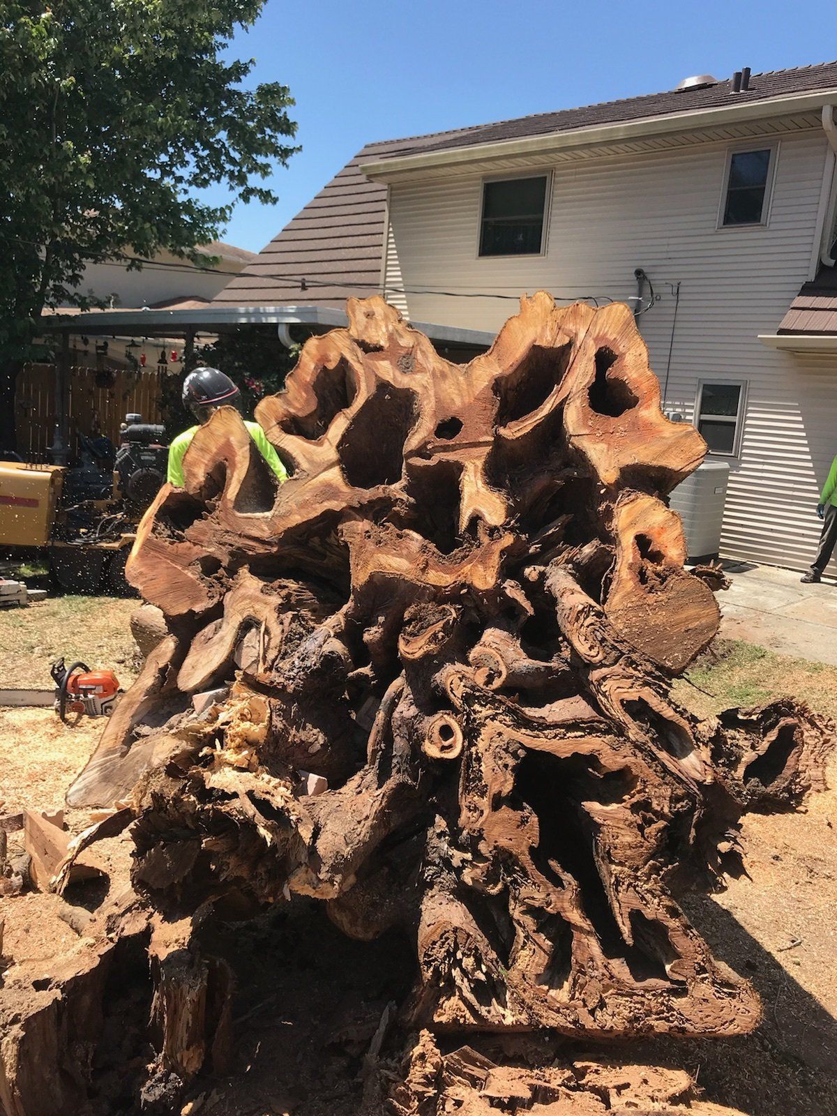 A large piece of wood is sitting in front of a house