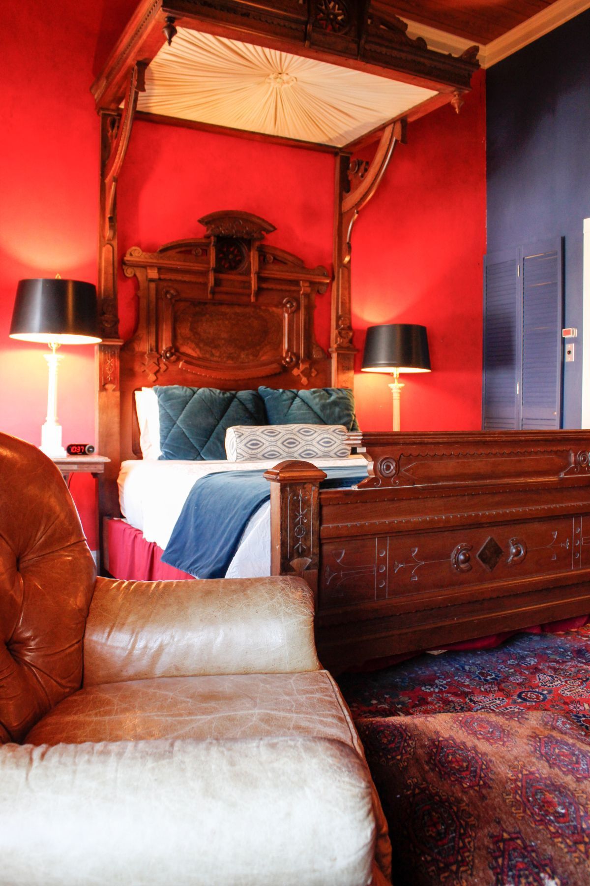 A bedroom with red walls and a canopy bed