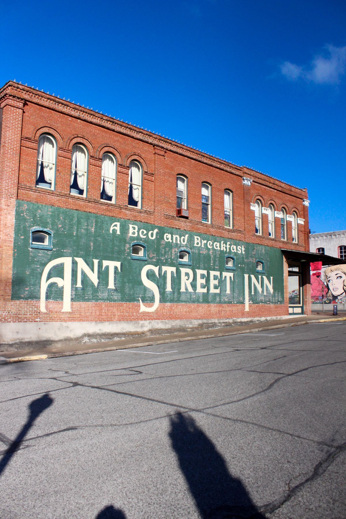 A brick building with a green sign that says ant street inn