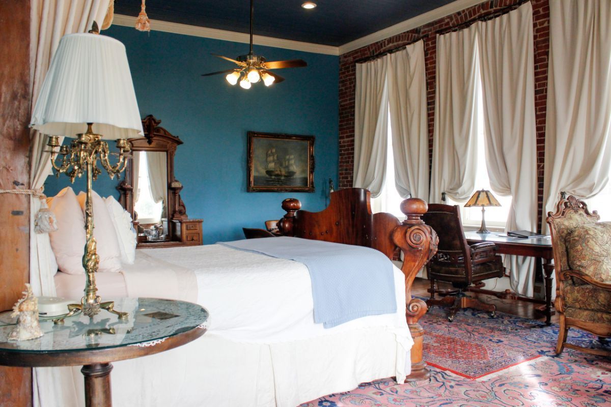 A bedroom with a blue ceiling and a large bed