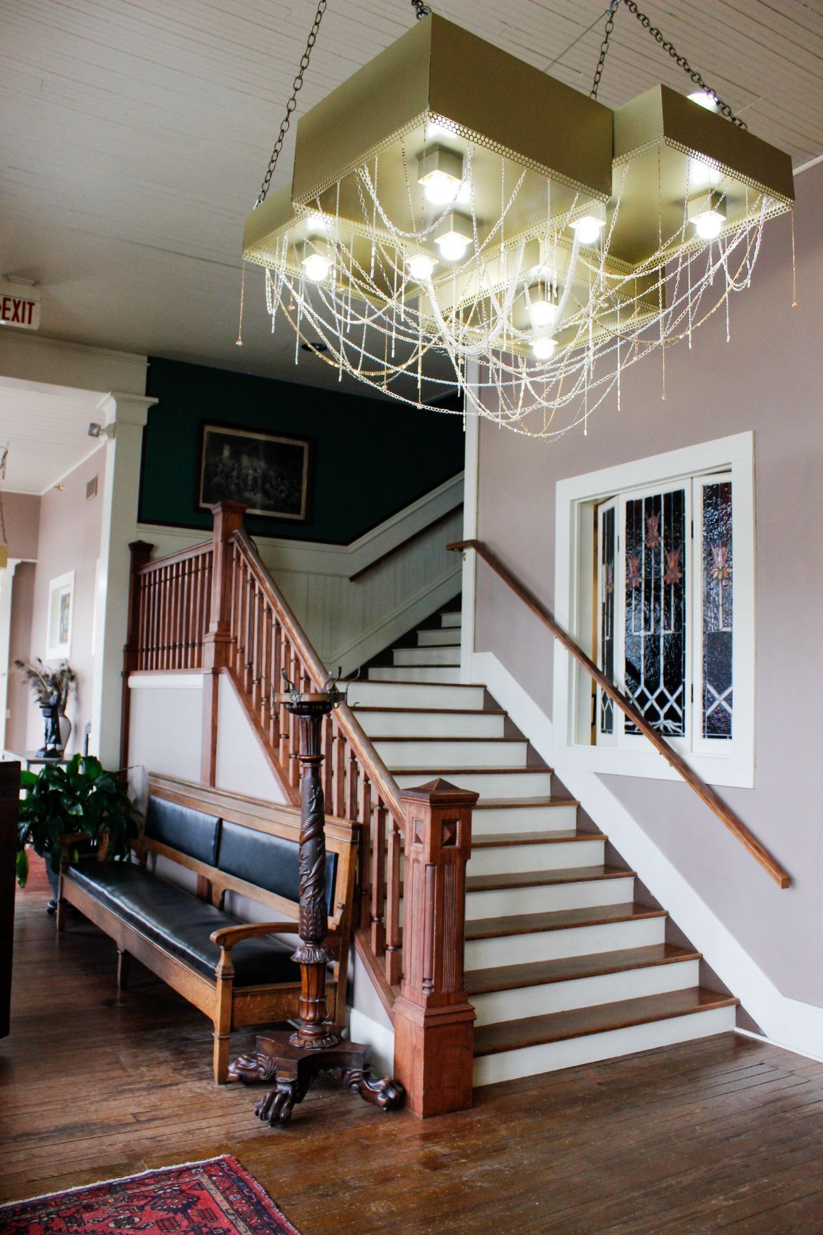A staircase with a chandelier hanging from the ceiling