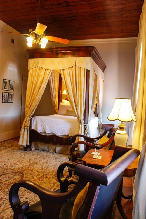 A bedroom with a canopy bed and a ceiling fan