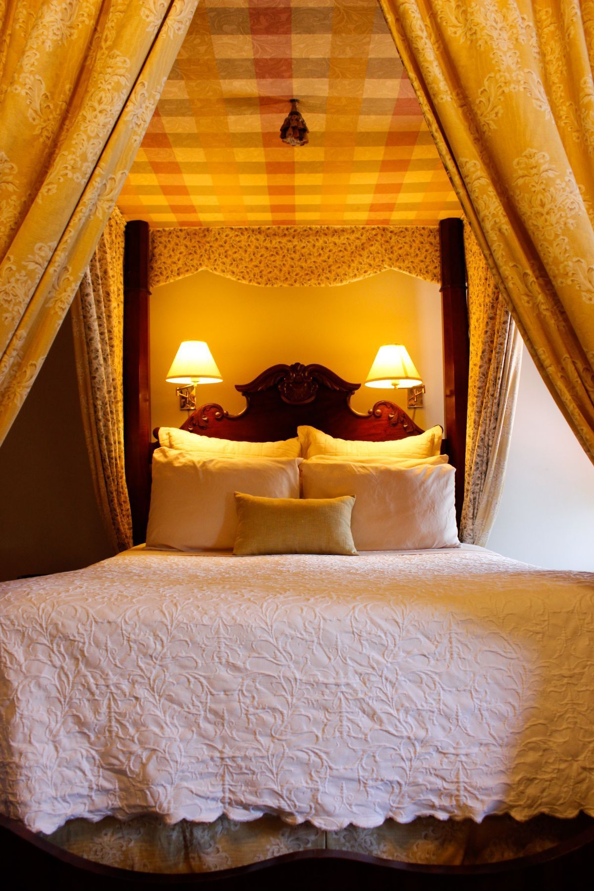 A bed with a canopy and two lamps on it