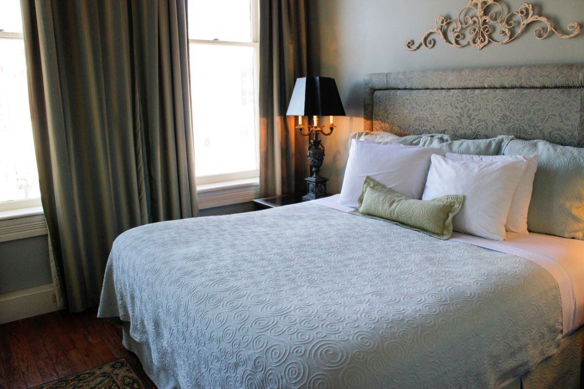 A hotel room with a bed and a lamp