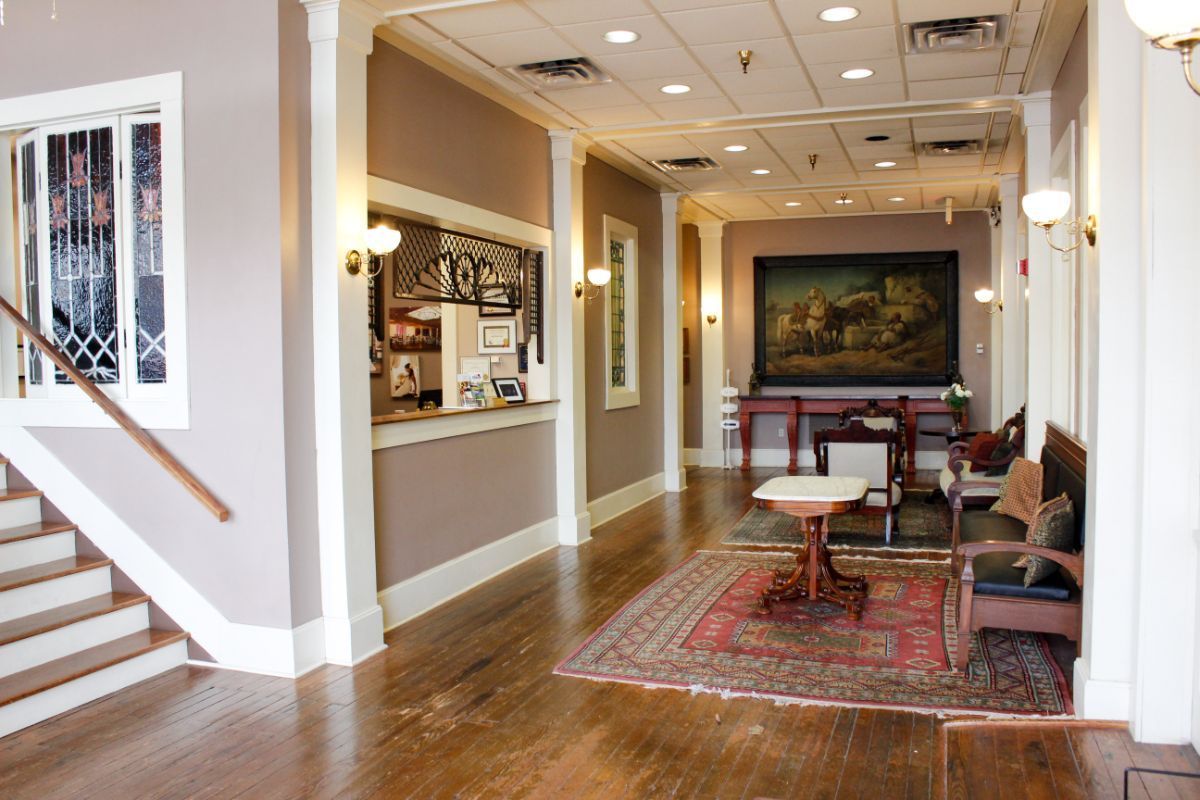 A hotel lobby with a table and chairs and a painting on the wall