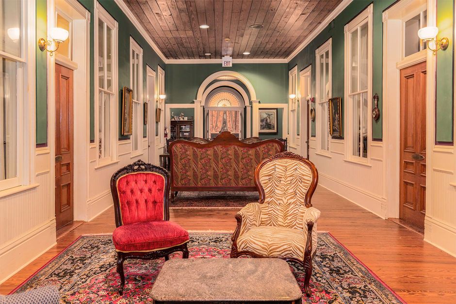 A living room with a couch , chairs , and a table.