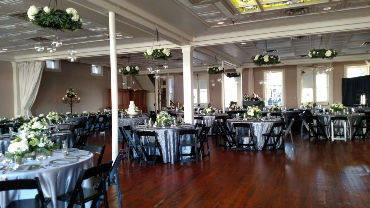 A large room with tables and chairs set up for a wedding reception.