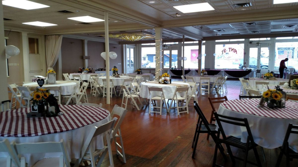 A large room with tables and chairs set up for a party.