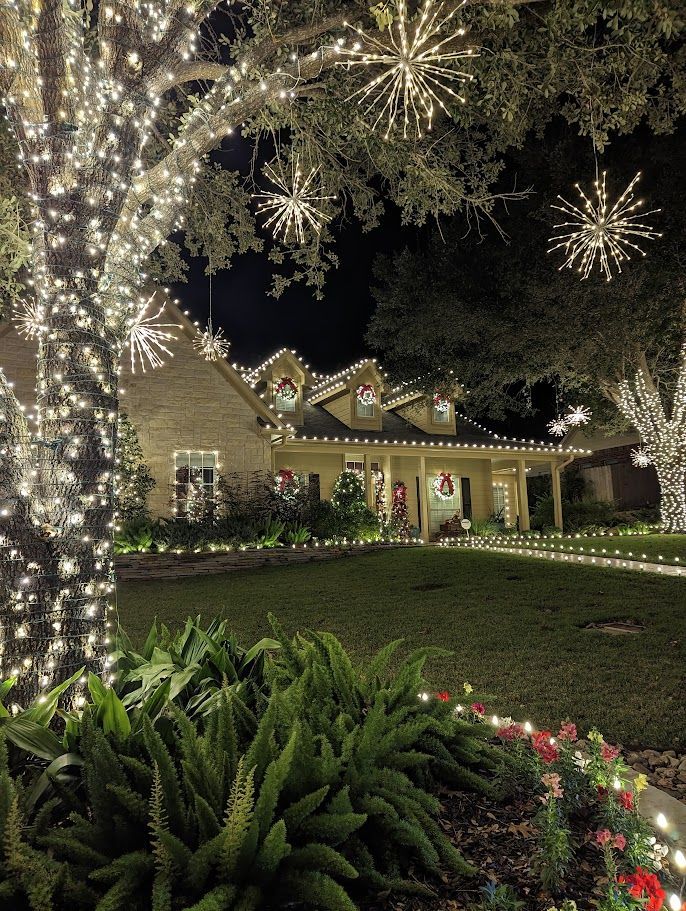 House decorated with white Christmas lights at night.