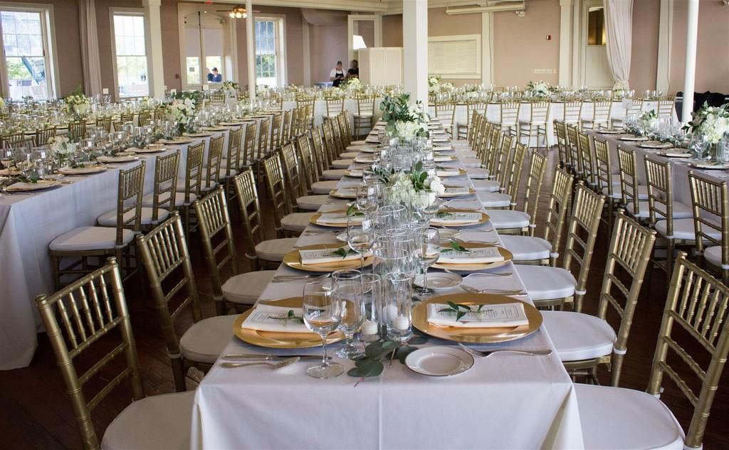 There are a lot of tables and chairs set up for a wedding reception.