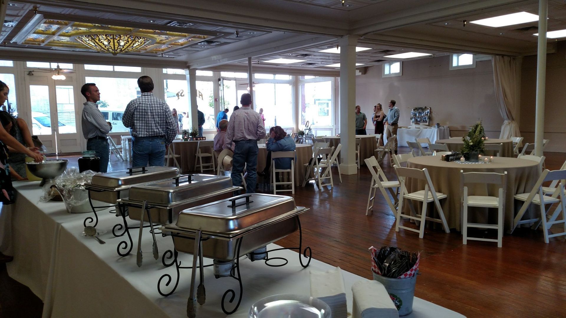 A large room filled with tables and chairs and a buffet table.