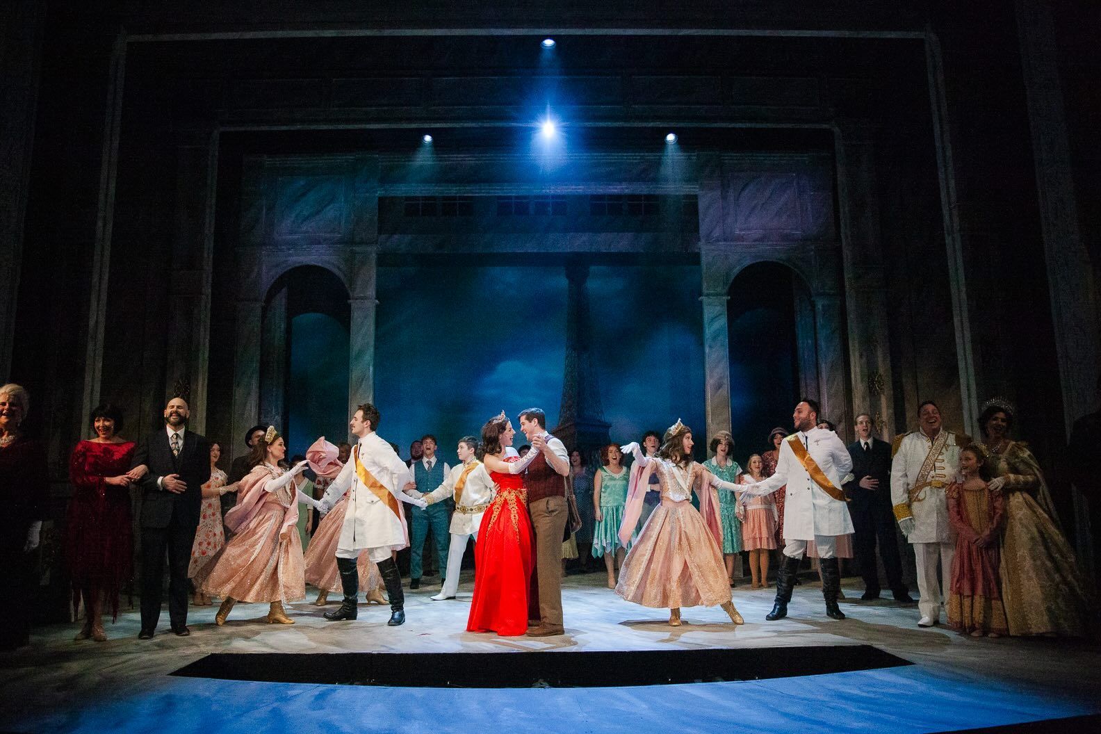 A group of people are dancing on a stage in a theater.