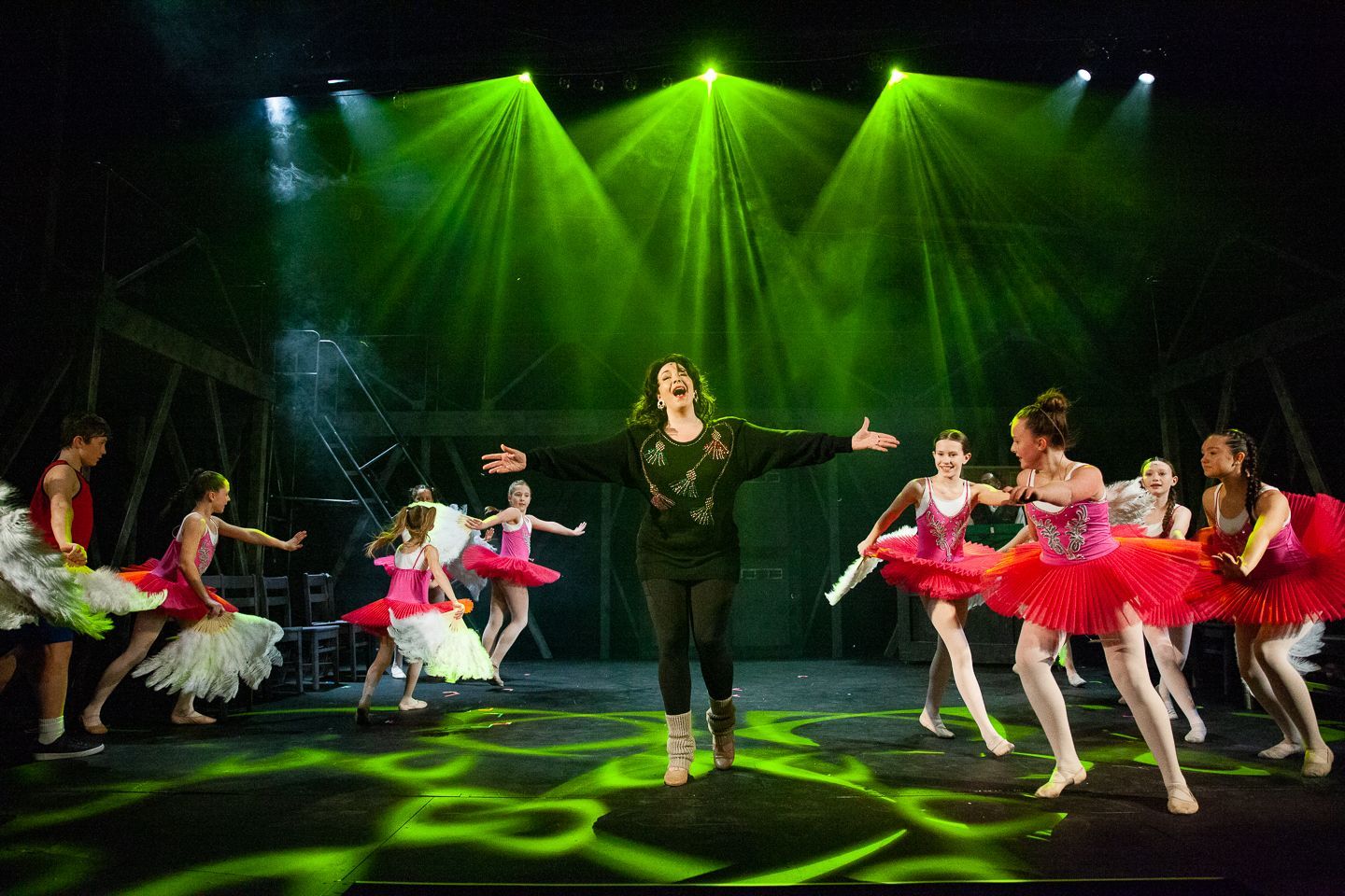 A group of young dancers are performing on a stage.