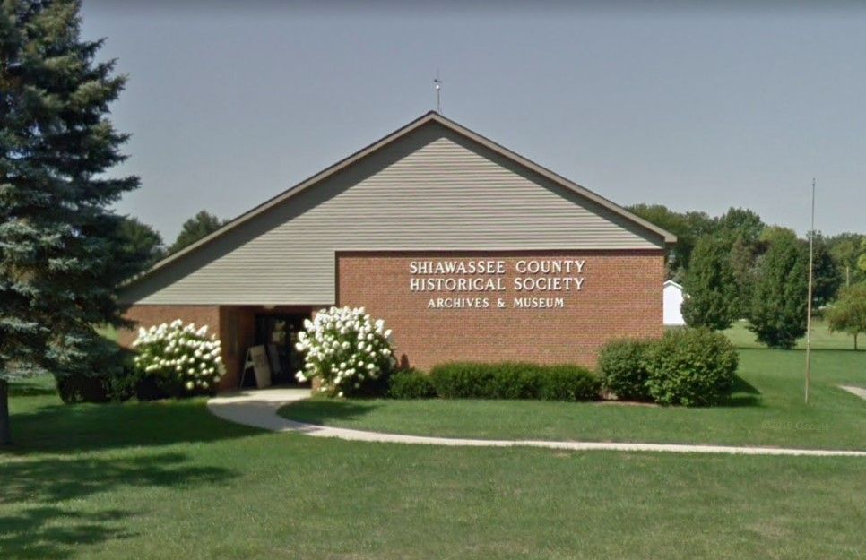 A brick building with a sign that says shiawassee county historical society archives & museum.