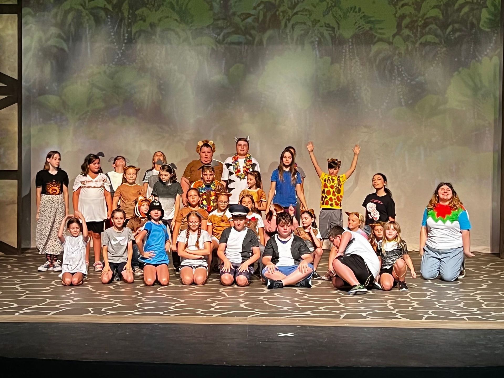 A group of children are posing for a picture on a stage.