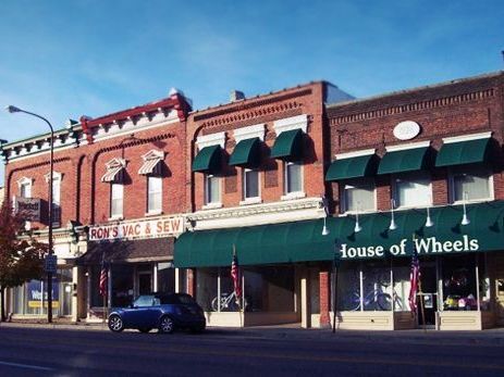 A car is parked in front of a store called house of wheels