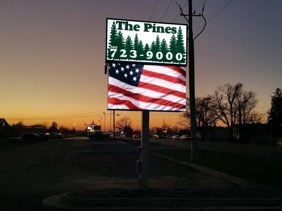 A sign for the pines has an american flag on it