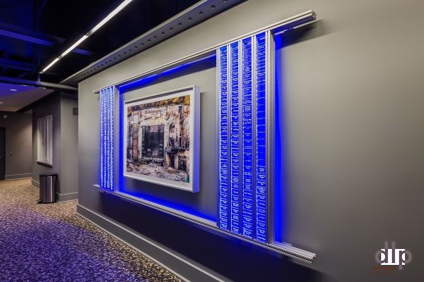 A hallway with a picture on the wall and blue lights.