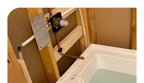 A bathtub is being installed in a bathroom under construction.