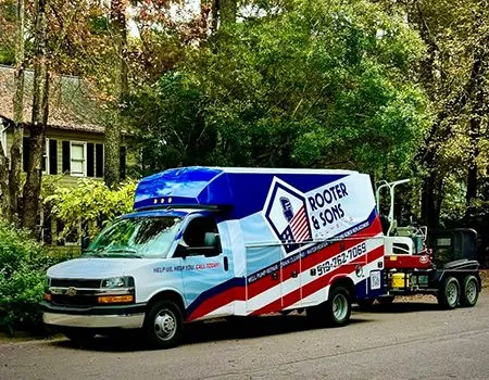 A rooster & sons van is parked in front of a house