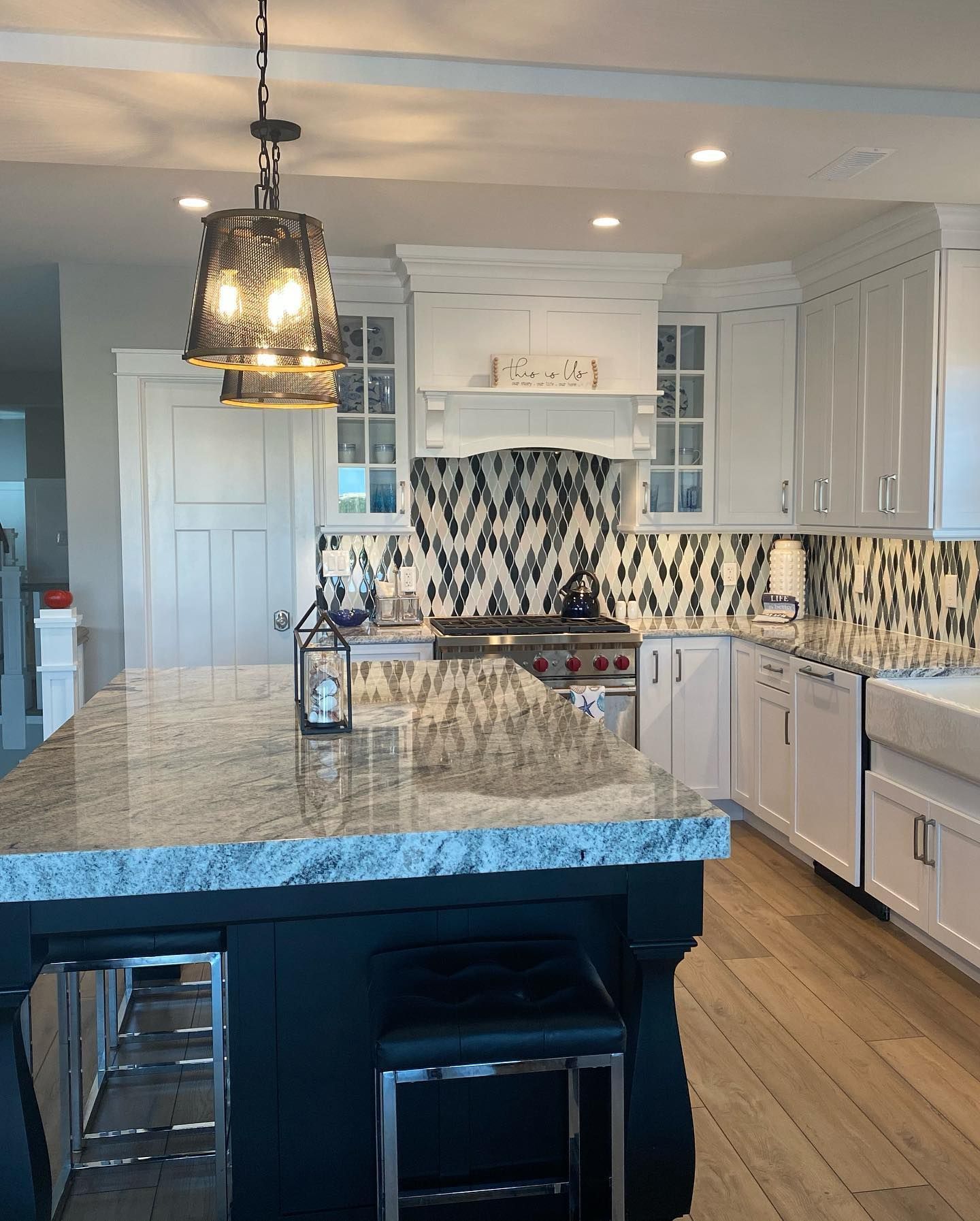 white kitchen with a granite island, black accents, and patterned backsplash remodeled by j.k. construction llc in strathmere, new jersey