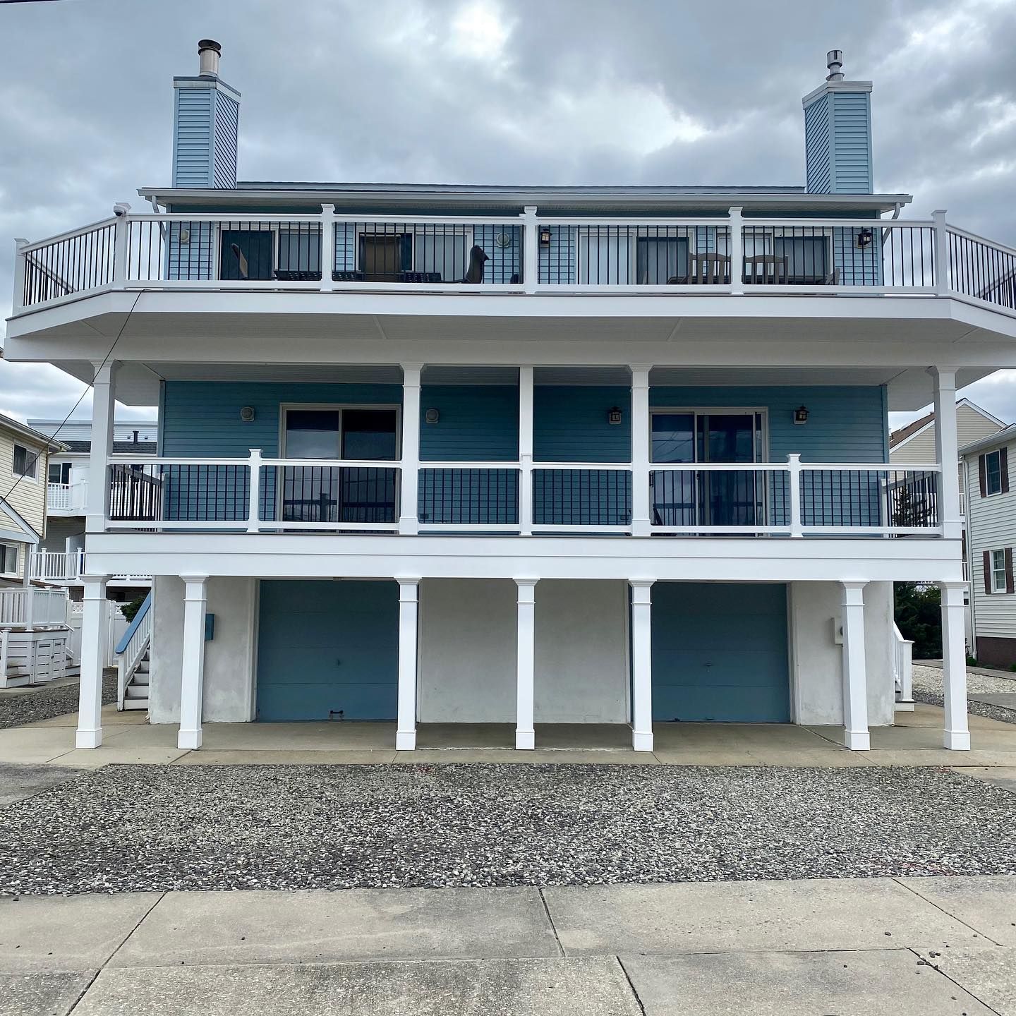Exterior remodel of a shore house with blue siding, white pillars and garage door in Cape May, NJ done by J.K. Construction LLC of Cape May Court House, NJ